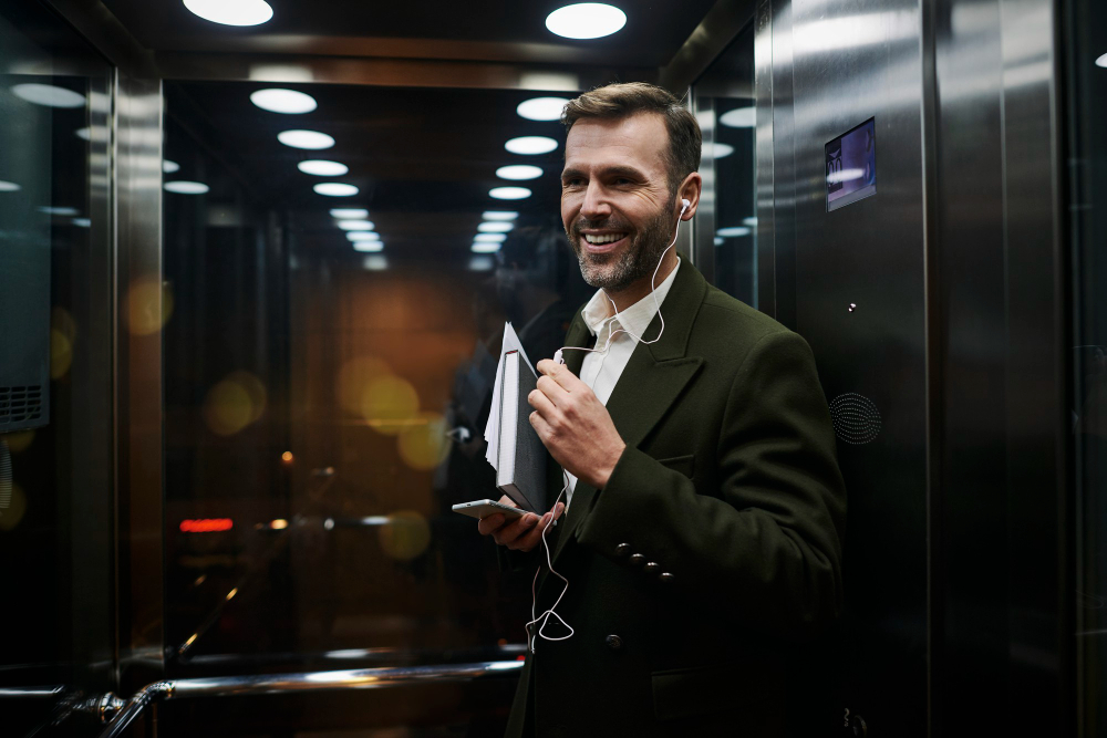 portrait-smiling-businessman-listening-music-elevator